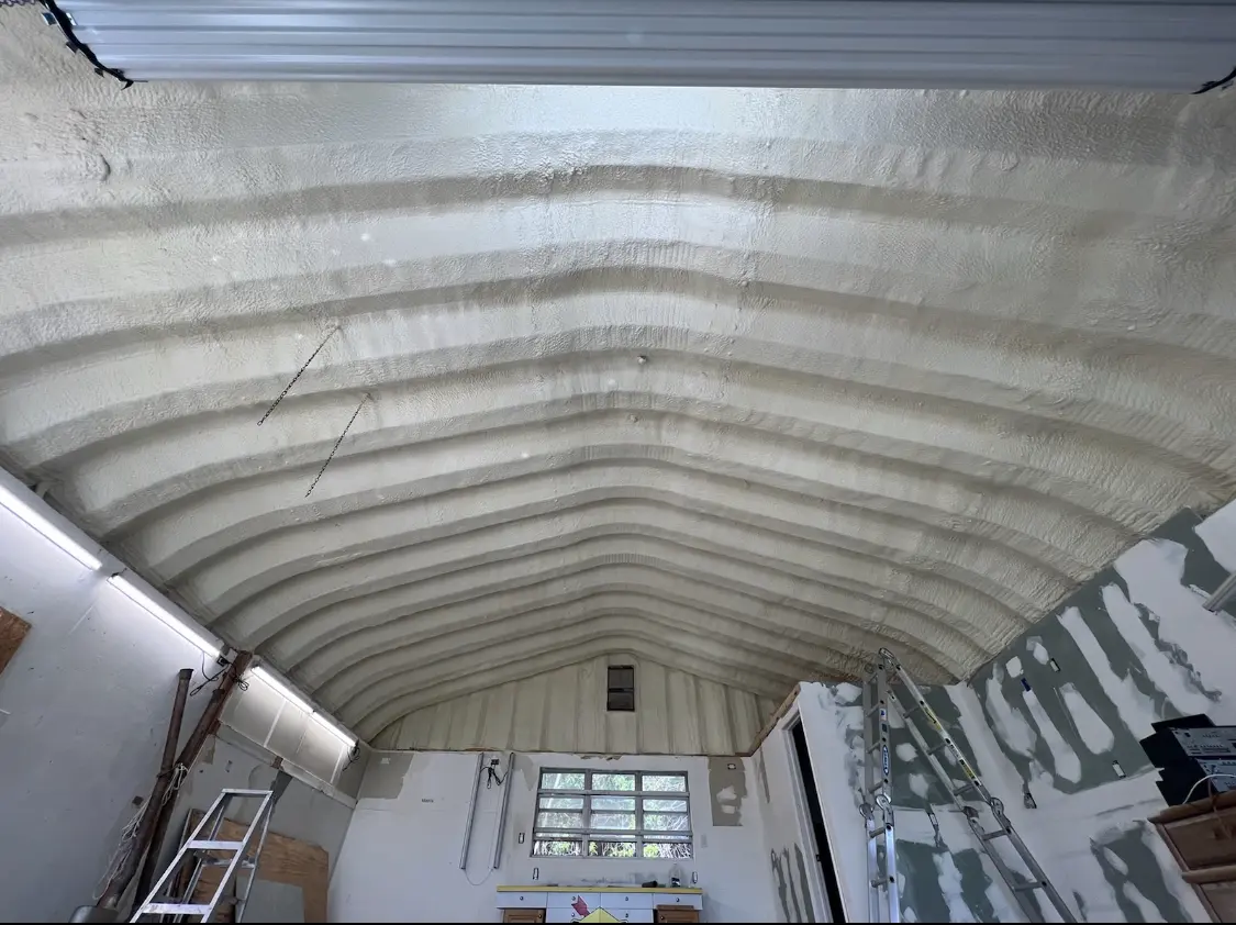 Spray polyurethane foam applied to the underside of a metal roof deck in Enoch